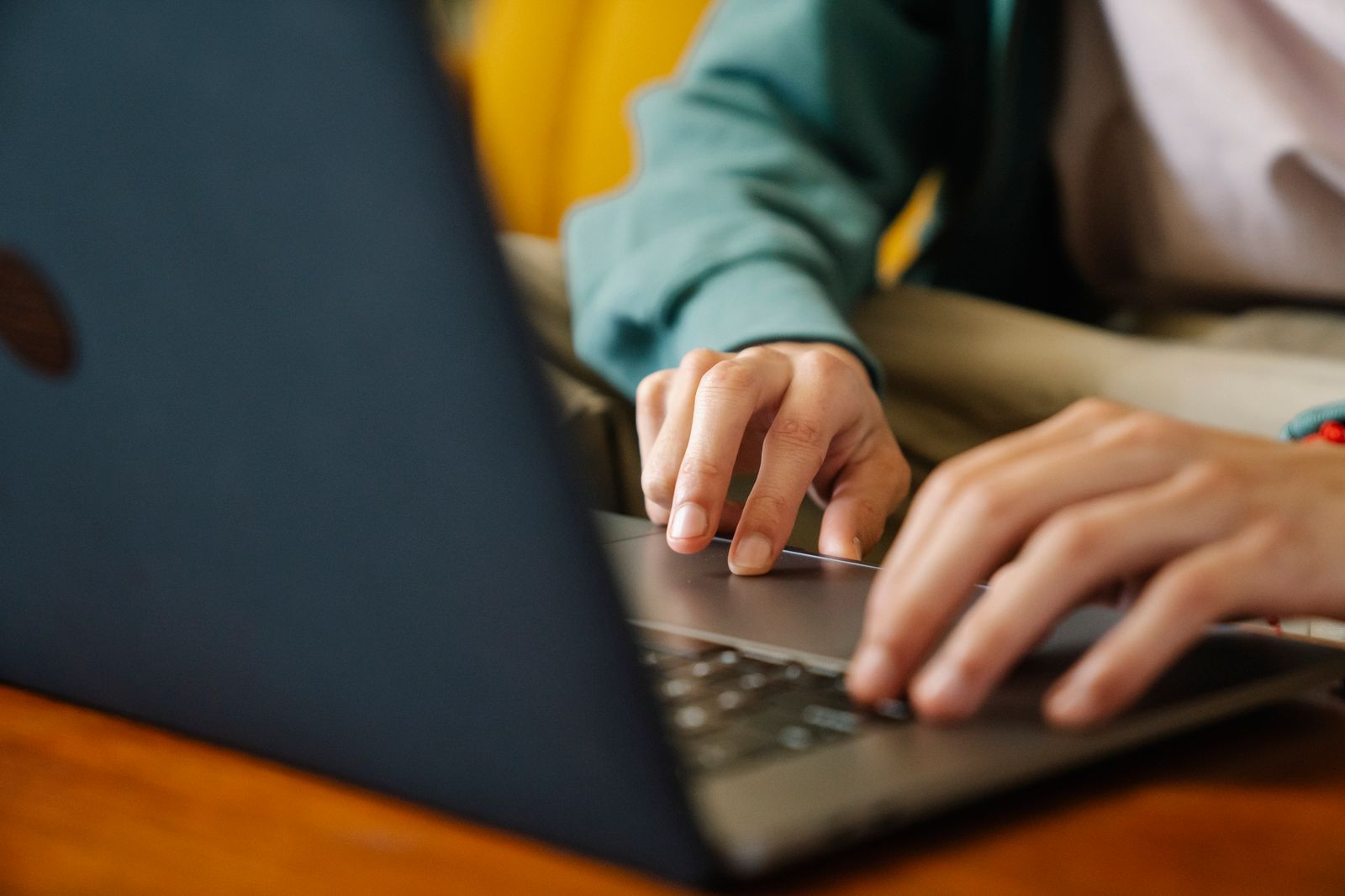 Person typing an AI prompt on a laptop to generate creative content